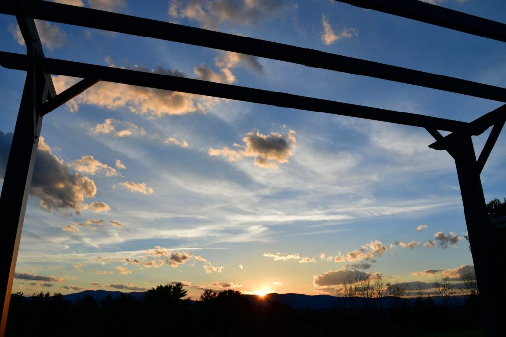 Beautiful sky at sunset with a pergola in the foreground and the mountains in the background.